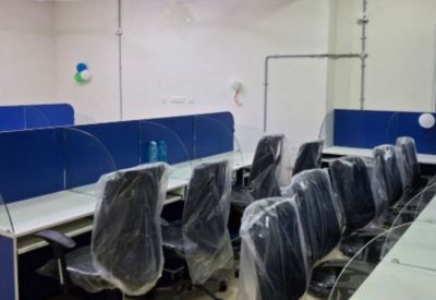 Bright coworking area with blue privacy dividers and black office chairs.