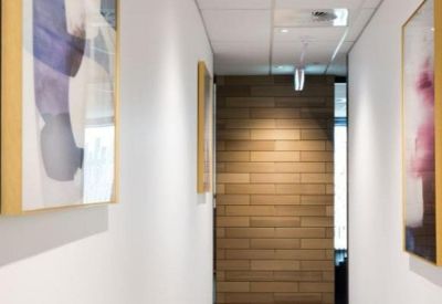 White office corridor featuring abstract colorful artwork on the walls.