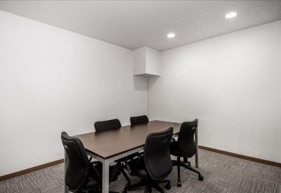 Professional meeting room with a dark wood table and six black chairs.