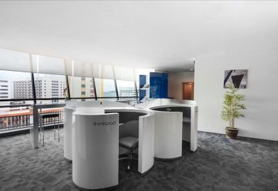 Coworking area featuring semi-enclosed white circular work pods and city views.