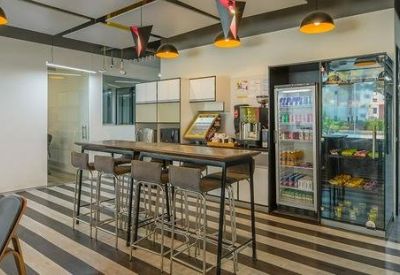Communal break area featuring a high-top table, striped flooring, and snacks.