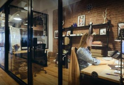 Bright private office suite with a brick feature wall and glass partitions.