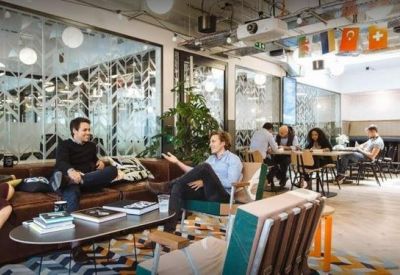 Vibrant communal breakout area with diverse seating and casual workspaces.