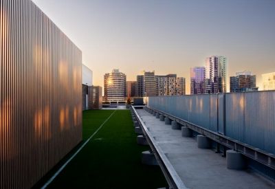 Rooftop garden area featuring a synthetic grass strip and views of surrounding skyscrapers.