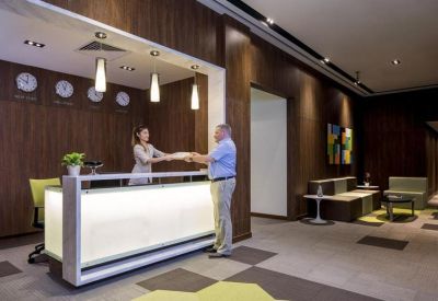 Modern reception desk with bright backlighting and wood paneling.