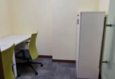 Private two-person office suite with green chairs and grey carpet.