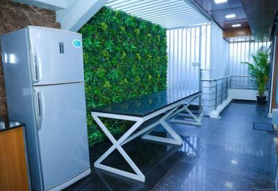 Breakout area with a long black high-top table and another green feature wall.