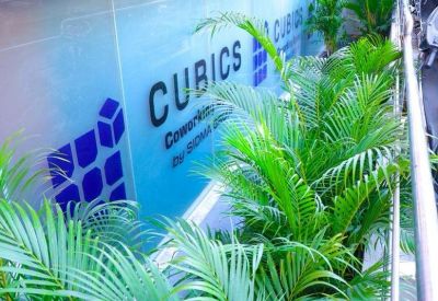 Exterior view showing green plants in front of the branded building glass.