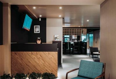 Modern reception area featuring a wood-paneled desk and a digital information screen.