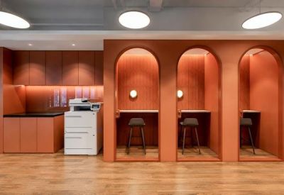 Built-in orange work booths and a printing station against a clean white wall.