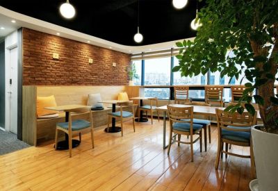 Cafe-style seating area with a brick feature wall and large windows.