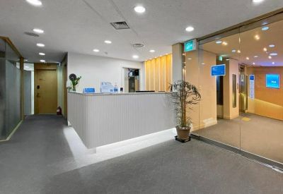 Modern reception lobby with a sleek white desk and warm wooden accents.