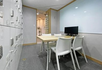 Small meeting room with white lockers and a whiteboard.