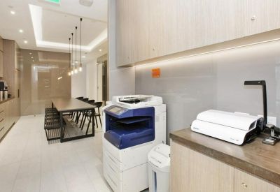Modern communal kitchen and breakout area with high-end appliances and long dining table.