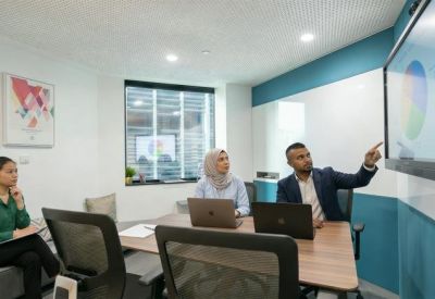 Modern meeting room with integrated technology and a large digital presentation screen.