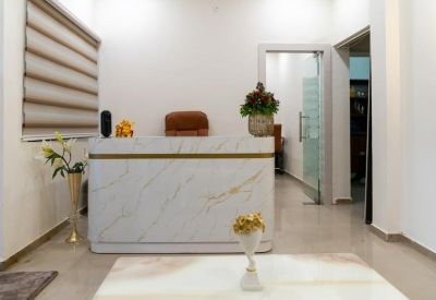 Reception area featuring a marble-patterned desk and modern window blinds.