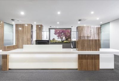 Professional reception desk featuring a mix of white stone and warm wood panelling.