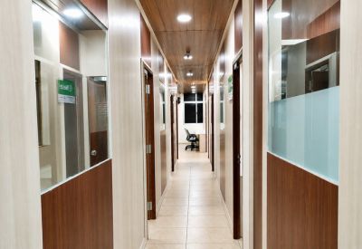 Long hallway at GT-CoWorks featuring wood-paneled ceilings and glass-partitioned office suites.