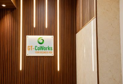 Branded reception wall with wood slats, vertical light strips, and the company logo.