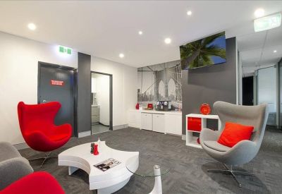 Stylish breakout lounge with vibrant red egg chairs and a modern coffee station.