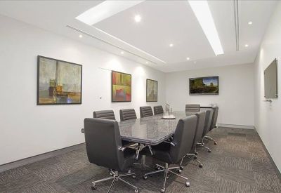 Professional boardroom with a long grey table and contemporary artwork.