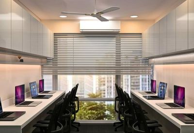 Symmetrical coworking area with rows of laptops and overhead storage.