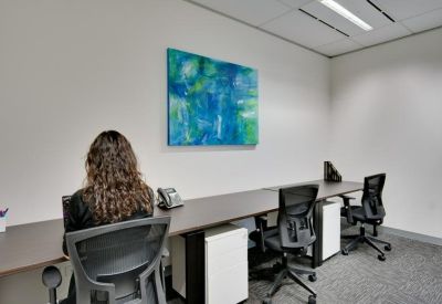 Shared workspace with white storage units and blue abstract wall art.