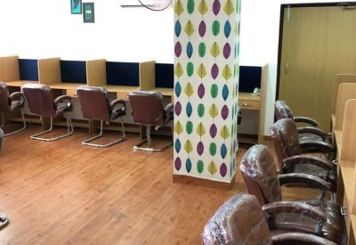 Bright workspace featuring colorful leaf-patterned pillars and brown leather seating.