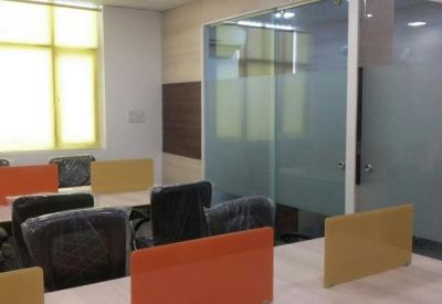 Meeting room with glass partitions, orange and yellow privacy screens, and black office chairs.