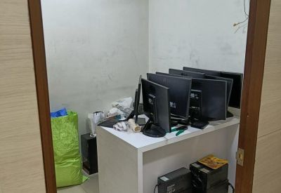 Compact server room with multiple monitors and computers.