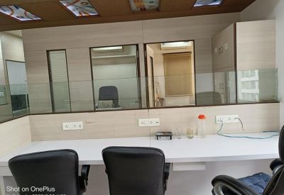 Dual workstation setup with glass partitions and a brown ceiling.