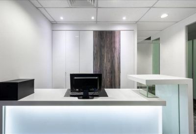 Sleek white reception desk with integrated lighting and wood-paneled accents.
