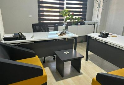 Modern office interior featuring stylish yellow and black armchairs and white desks.