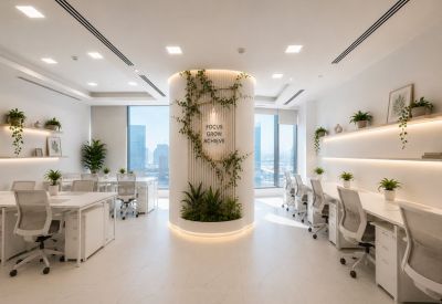 Bright coworking area with white desks and a central architectural column wrapped in climbing green vines.