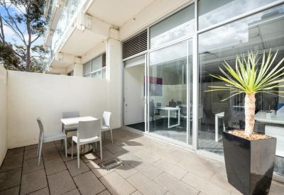 Private outdoor patio with a table and chairs for meetings.