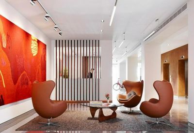 Modern lobby area with stylish egg chairs, warm lighting, and bold abstract art.