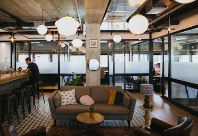 Spacious reception lounge with grey sofa and modern globe pendant lighting.