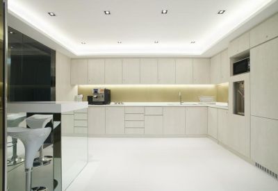 Minimalist all-white kitchen and break area with modern cabinetry.