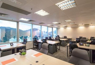 Bright open-plan office with multiple workstations and large windows.
