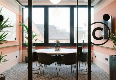 Small meeting room with a round table and warm peach-toned walls.