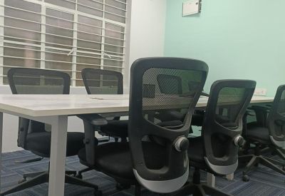 Private four-person meeting room with ergonomic chairs and a light green accent wall.