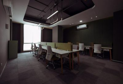 Modern workspace with dark walls, minimalist ceiling lights, and workstations by a large window.
