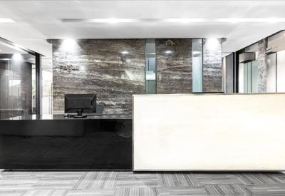 Polished reception desk featuring a black granite counter and a stone-textured feature wall.