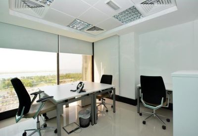 Bright corner office suite with two workstations and a large window overlooking the coastline.