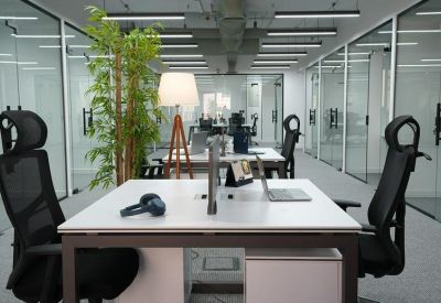 Open-plan office space with paired desks and lighting.