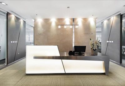 Futuristic reception desk with integrated lighting and a stone-textured feature wall.