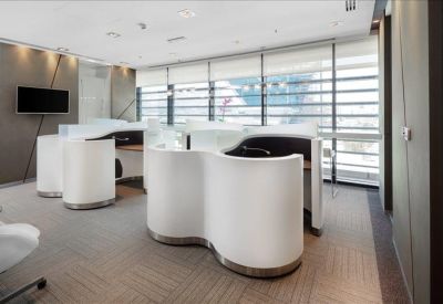 Modern open-plan workspace featuring unique S-shaped white privacy desks.