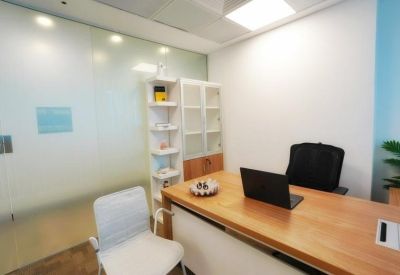 Close-up of a wooden office desk featuring a laptop and a white storage cabinet.