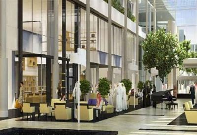Bright, airy lobby with tall glass walls, seating areas, and indoor trees.