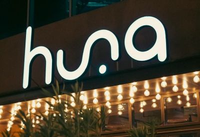Building entrance with illuminated 'huna' sign.